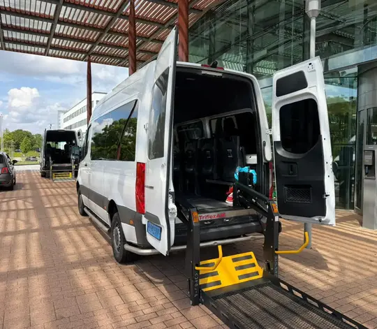 Professionele rolstoeltaxi chauffeur helpt klant in IJmuiden
